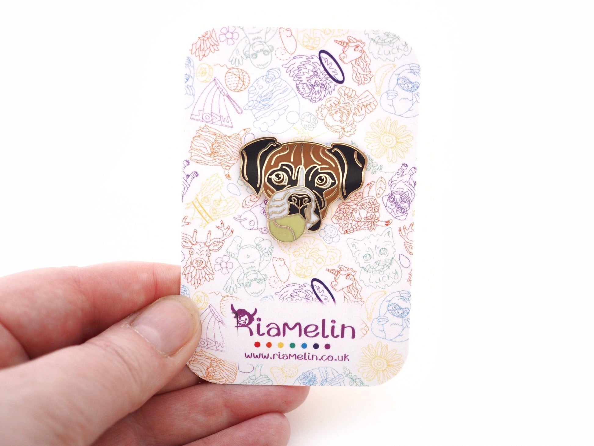 A photo of a Boxer dog enamel pin on a Riamelin branded backing card